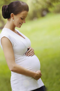 фото беременной девушки на зеленом фоне